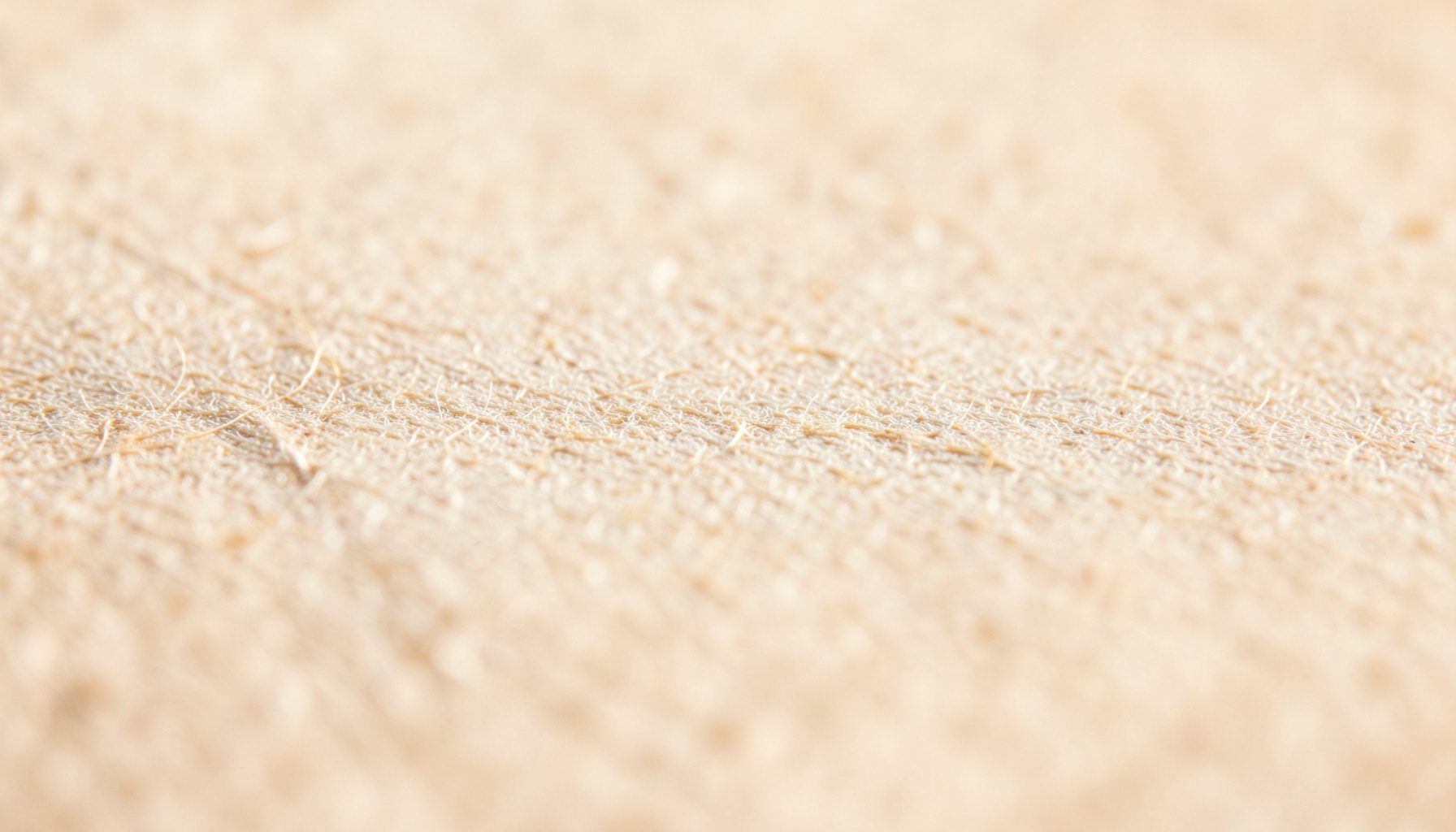 Primer plano extremo de la textura de papel envejecido, tonos crema y beige con fibras sutiles, iluminación cálida y suave que evoca intimidad y calma lectora.
