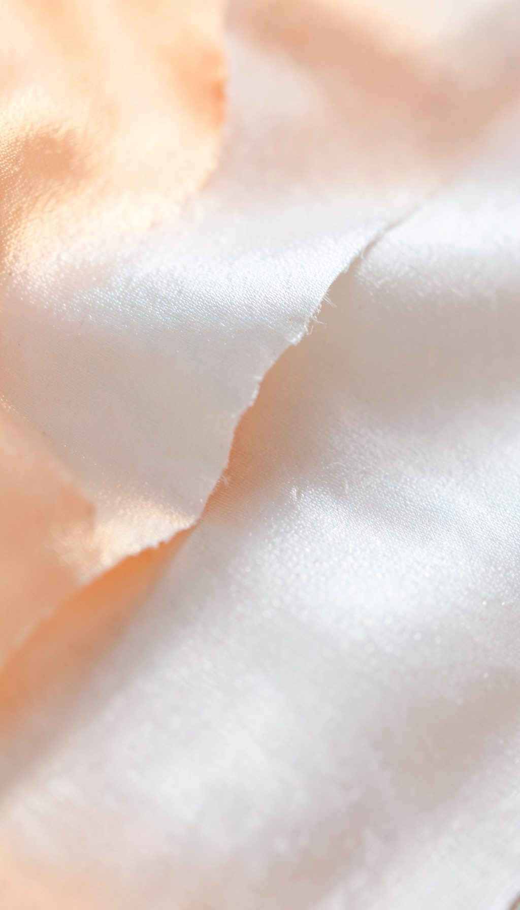 Primer plano de papel satinado blanco roto con microarrugas y reflejos tenues, iluminación de estudio suave.
