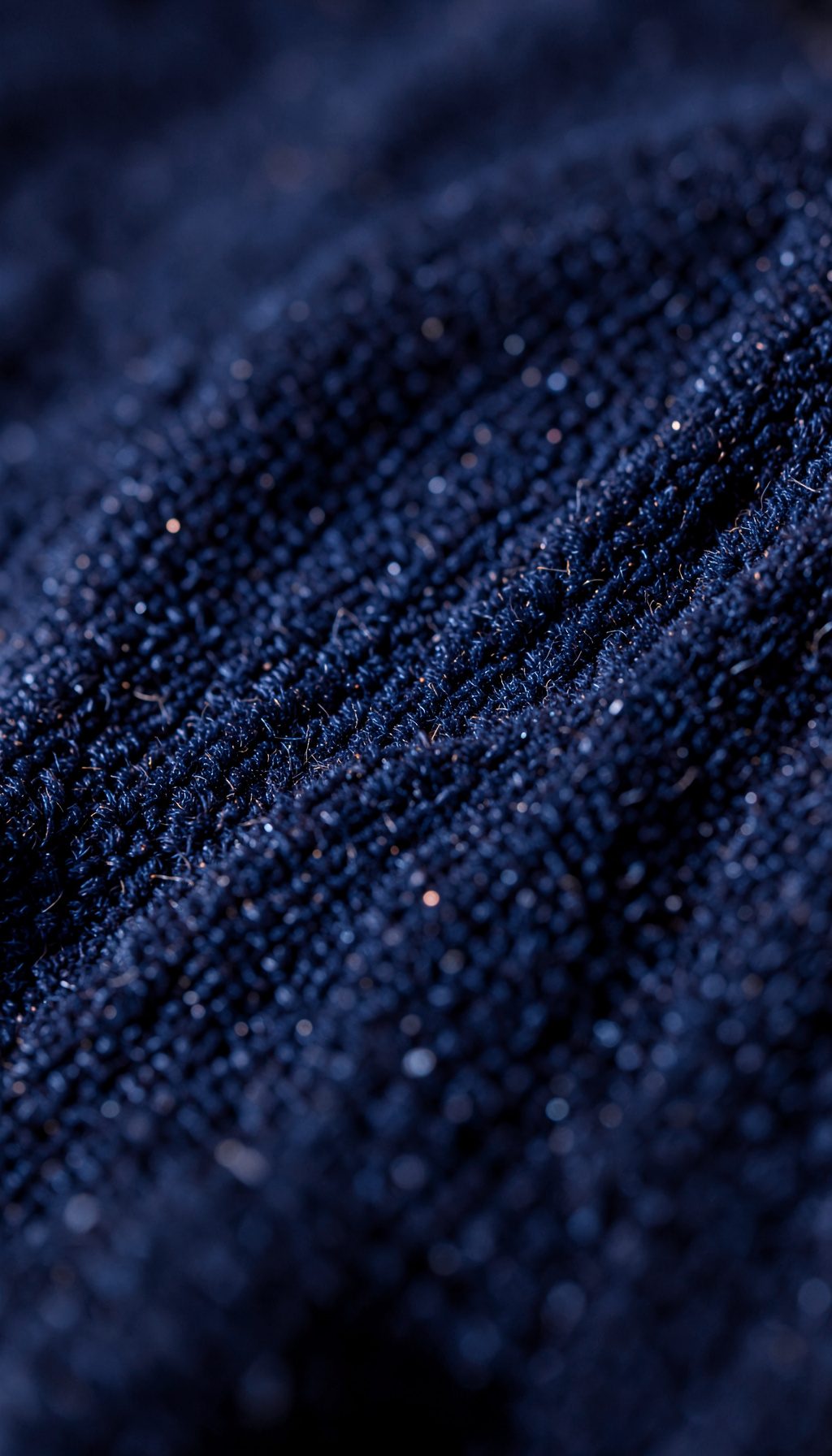 Superficie de terciopelo azul medianoche con marcas de presión y brillos sutiles, macro fotográfico con luz lateral.